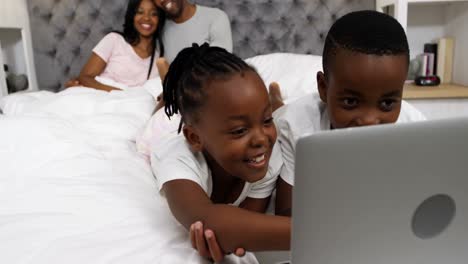 Kinder-Benutzen-Laptop,-Während-Ein-Paar-Im-Hintergrund-Lächelt,-4K