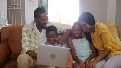 Family-using-laptop-in-living-room-4k