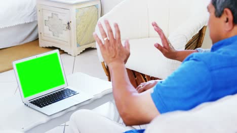 Senior-couple-using-laptop-in-living-room-4k