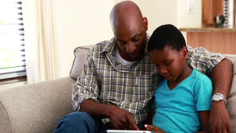 Padre-E-Hijo-Usando-Tableta-Digital-En-La-Sala-De-Estar-4k