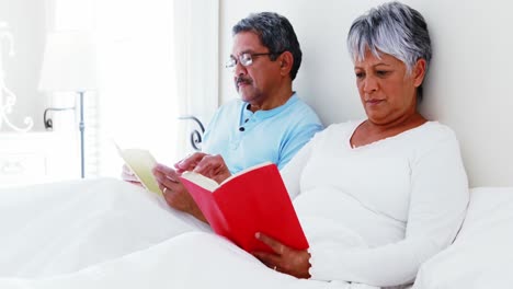 Senior-couple-using-laptop-4-reading-book-4k