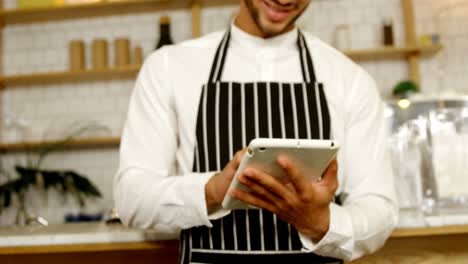 Smiling-waiter-using-digital-tablet-4-4k
