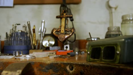 Various-tools-and-jewellery-on-wooden-table-4k