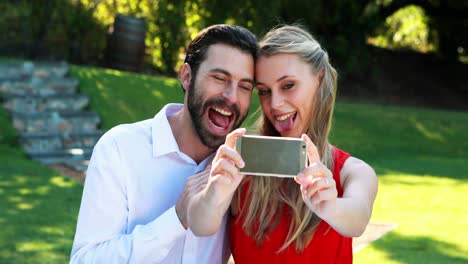 Couple-taking-selfie-with-mobile-phone-in-outdoor-restaurant-4k
