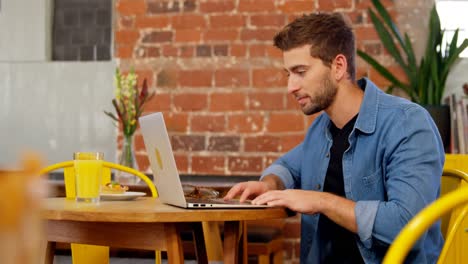 Handsome-man-using-laptop-at-table-4k