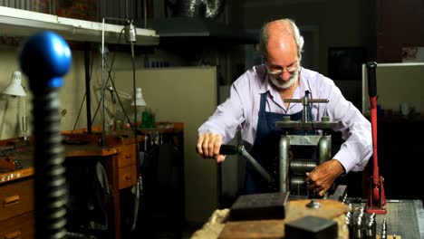 Goldsmith-working-on-machine-in-workshop-4k