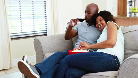 Couple-having-snacks-while-watching-television-in-living-room-4k