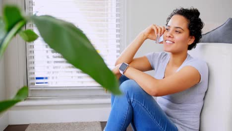 Happy-woman-talking-on-mobile-phone-in-living-room-4k