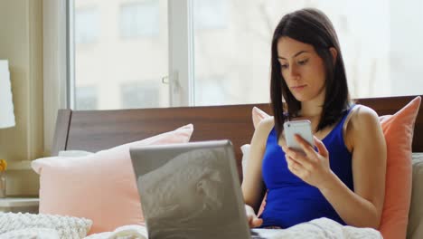 Young-woman-using-mobile-phone-and-laptop-4k