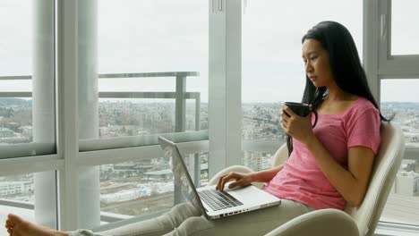 Mujer-Usando-Laptop-Mientras-Toma-Una-Taza-De-Café-4k