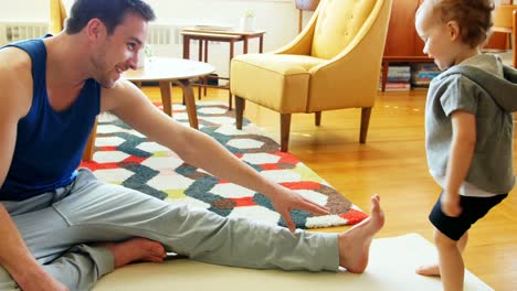 Father-exercising-with-his-baby-boy-in-living-room-4k