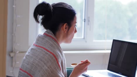 Woman-looking-at-laptop-while-having-breakfast-4k