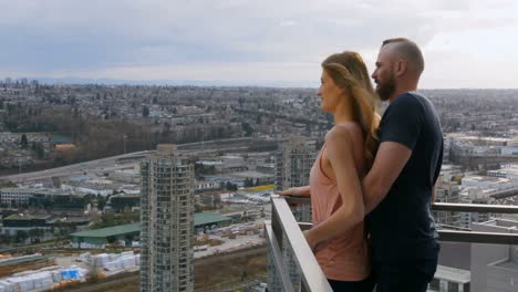 Couple-pointing-at-distance-in-balcony-4k