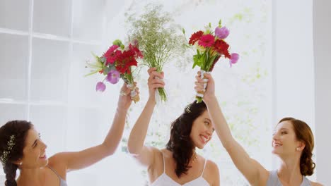 Bridesmaids-and-bride-having-fun-holding-flowers-in-the-air-4K-4k
