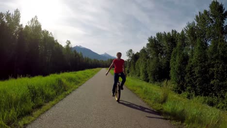 Woman-riding-unicycle-on-countryside-road-4k
