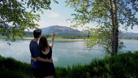 Couple-standing-with-arm-around-watching-the-lake-4k