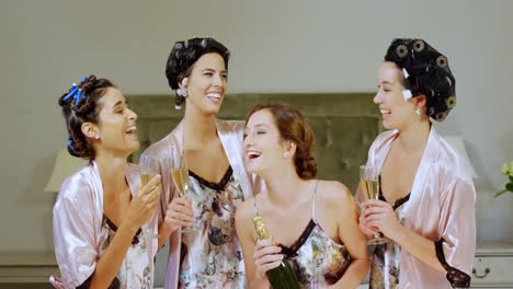 Four-happy-bridesmaids-in-nightdress-having-a-glass-of-champagne-4K-4k