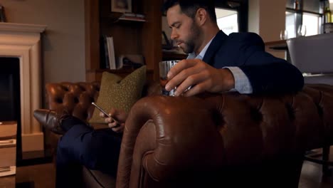 Businessman-using-mobile-phone-on-sofa-4k