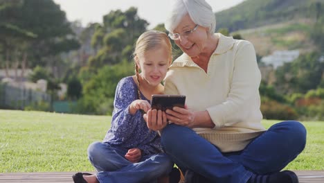 Grandmother-and-little-girl-sitting-and-using-tablet-4K-4k