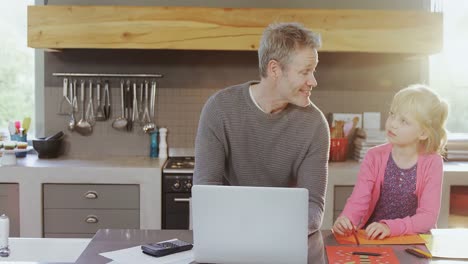 Father-using-laptop-while-interacting-with-daughter-4k