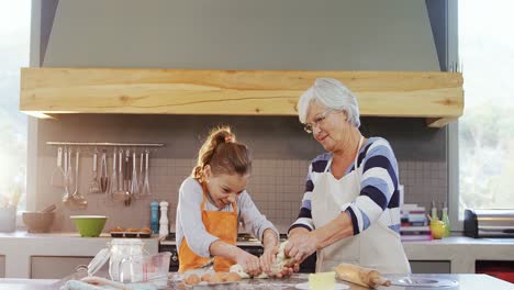 Happy-grandmother-and-child-in-apron-kneading-dough-4K-4k