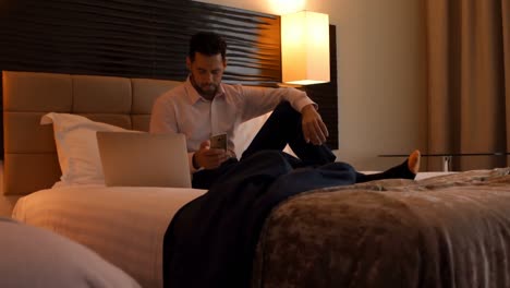 Businessman-using-mobile-phone-in-bedroom-4k