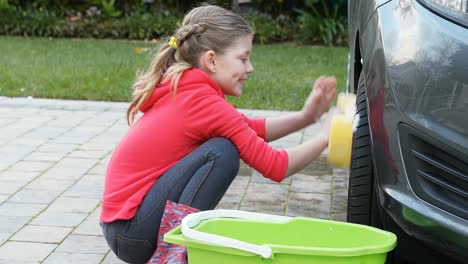 Little-girl-washing-car-with-a-sponge-4K-4k