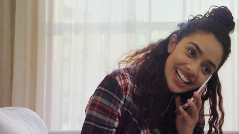 Woman-laughing-while-talking-on-phone-at-home-4K-4k