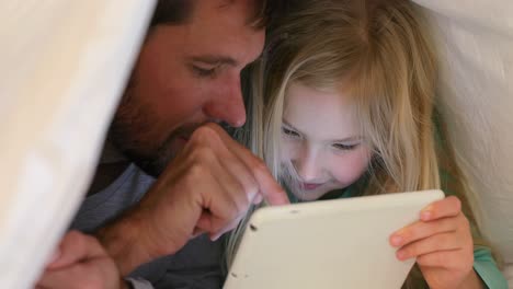 Happy-father-and-daughter-covered-with-blanket-using-tablet-4K-4k