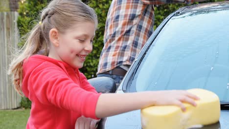Happy-daughter-and-father-washing-car-with-sponge-4K-4k