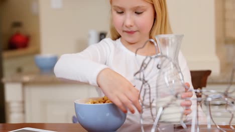 Little-girl-pouring-milk-into-breakfast-in-the-kitchen-4K-4k