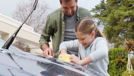 Happy-little-girl-helping-her-father-to-cleaning-up-the-car-with-sponge-4K-4k