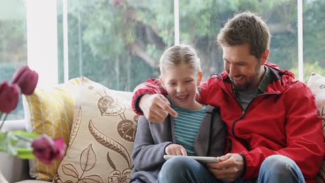 Glücklicher-Vater-Und-Tochter-Sitzen-Auf-Dem-Sofa-Und-Nutzen-Sein-Tablet-4k-4k
