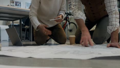 Colleagues-discussing-over-blueprint-with-each-other-4k