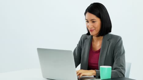 Businesswoman-using-laptop-at-desk-4k