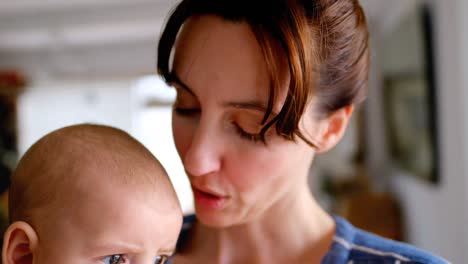 Young-mom-holding-and-kissing-her-baby-at-home-4k