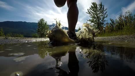 Rear-view-of-fit-woman-jogging-through-puddle-4k