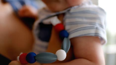 Cute-little-baby-carrying-pacifier-and-mother-holding-him-at-home-4k