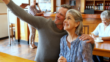 Senior-couple-taking-selfie-with-mobile-phone-in-restaurant-4k