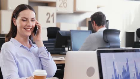 Female-executive-talking-on-phone-while-colleagues-working-in-background-4k