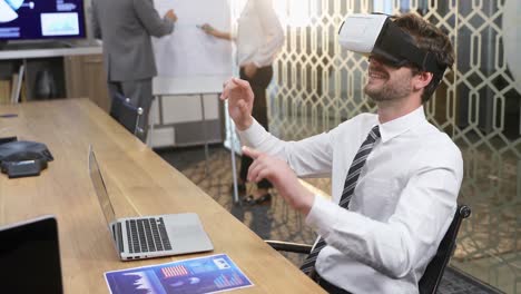 Executive-using-virtual-reality-headset-while-colleagues-discussing-over-flip-chart-4k