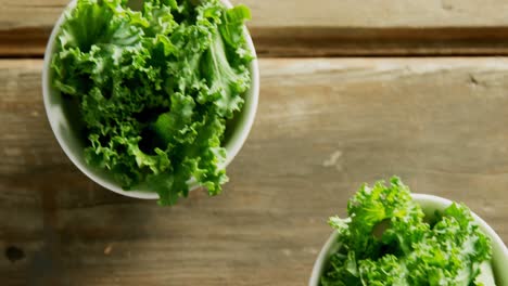 Grüne-Salatblätter-In-Einer-Schüssel-Auf-Einem-Holztisch-4k-4k