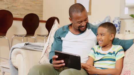 Vater-Und-Sohn-Nutzen-Digitales-Tablet-Im-Wohnzimmer-4k