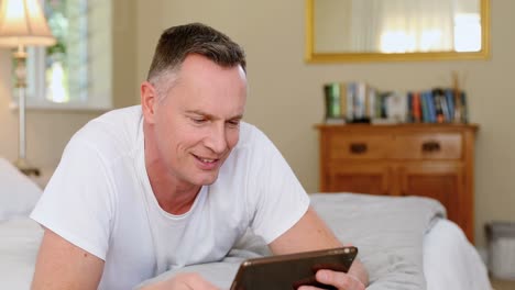Mann-Nutzt-Digitales-Tablet,-Während-Er-Sich-Auf-Dem-Bett-Entspannt-4k