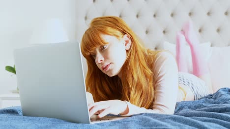 Beautiful-woman-using-laptop-while-relaxing-on-bed-4k