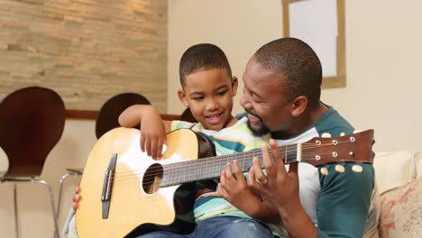 Vater-Und-Sohn-Spielen-Gitarre-Im-Wohnzimmer-4k