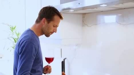 Man-cooking-food-while-having-glass-of-red-wine-4k