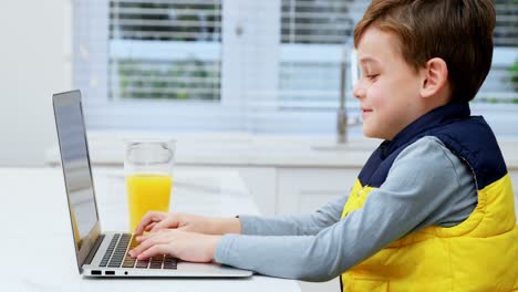 Boy-using-laptop-in-kitchen-4k