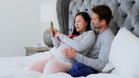 Hombre-Y-Mujer-Embarazada-Mirando-Ecografía-En-El-Dormitorio-4k