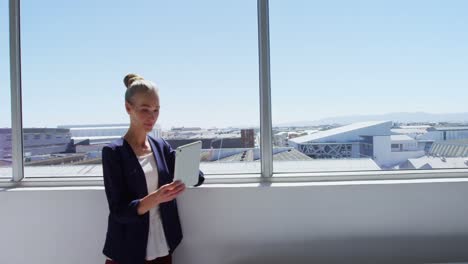 Businesswoman-with-digital-tablet-standing-near-the-window-4K-4k